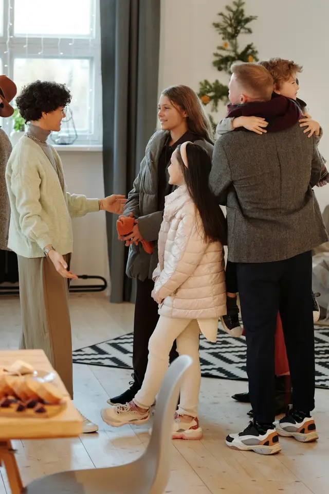A women greets a family at an event.